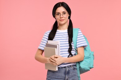 Student with books and backpack on pink background