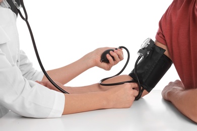 Photo of Doctor checking patient's blood pressure against white background, closeup. Cardiology concept