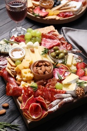 Photo of Tasty assorted appetizers served on black wooden table