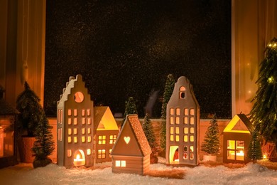 House shaped lanterns and Christmas decor on windowsill indoors