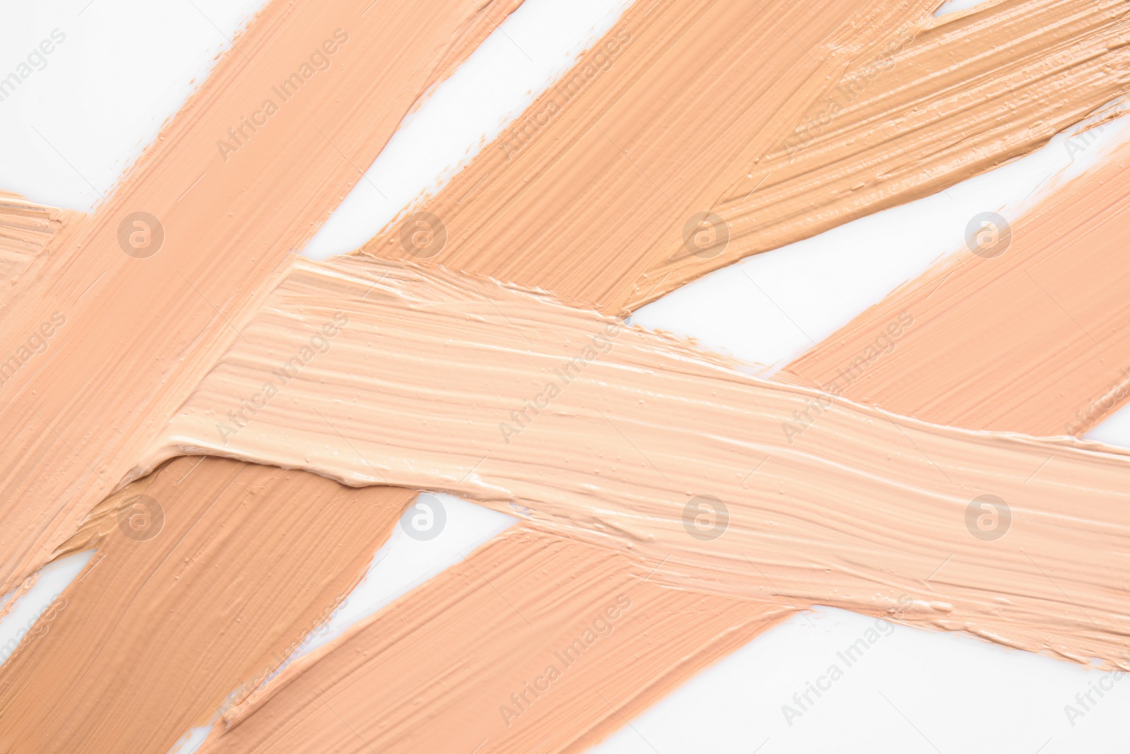 Photo of Samples of different foundation shades on white background, top view