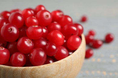 Photo of Tasty ripe cranberries on grey table, closeup