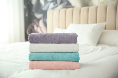 Soft clean towels on bed at home