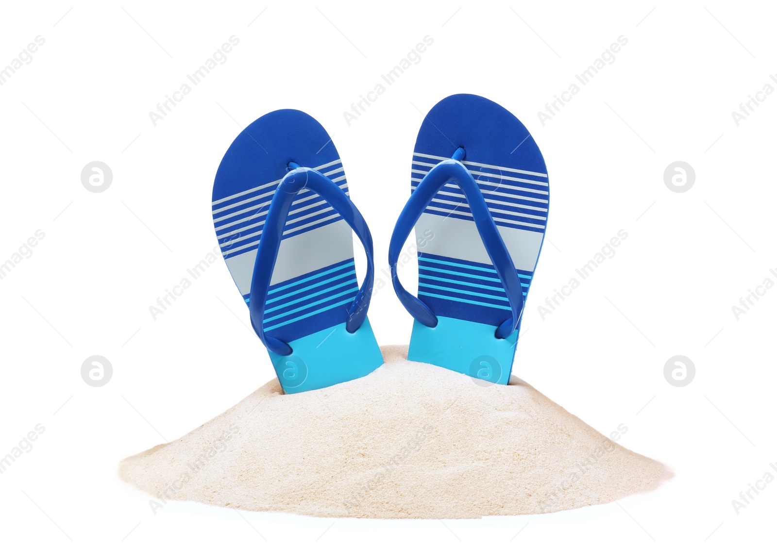 Photo of Striped flip flops in sand on white background