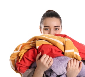 Photo of Young woman holding pile of dirty laundry on white background