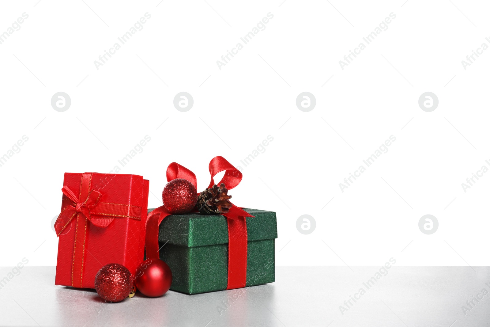 Photo of Christmas gifts in beautiful decorated boxes on grey table against white background, space for text