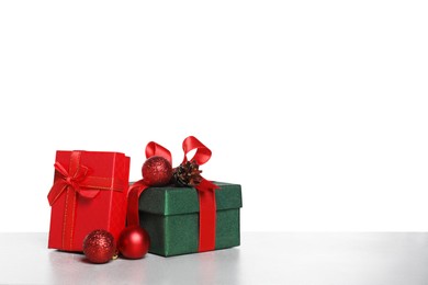 Photo of Christmas gifts in beautiful decorated boxes on grey table against white background, space for text