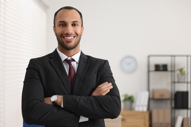 Portrait of smiling young man in office, space for text. Lawyer, businessman, accountant or manager