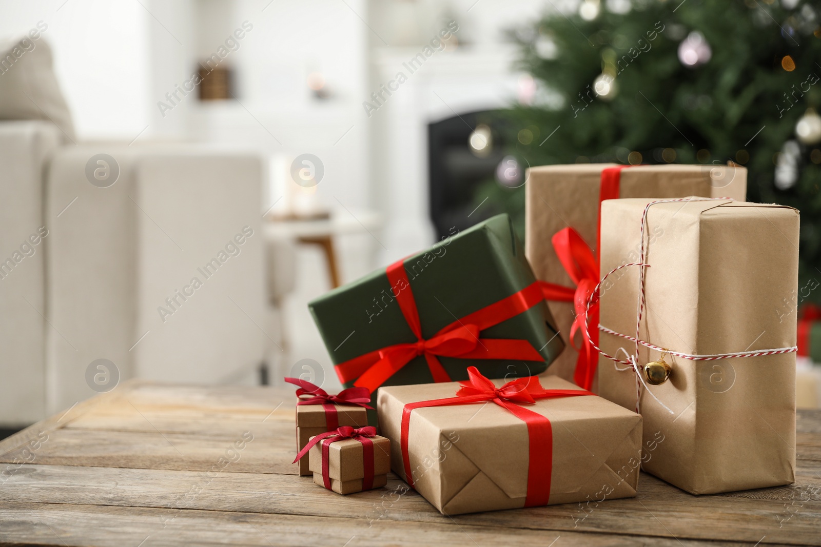 Photo of Beautifully wrapped Christmas gifts on wooden table indoors, space for text