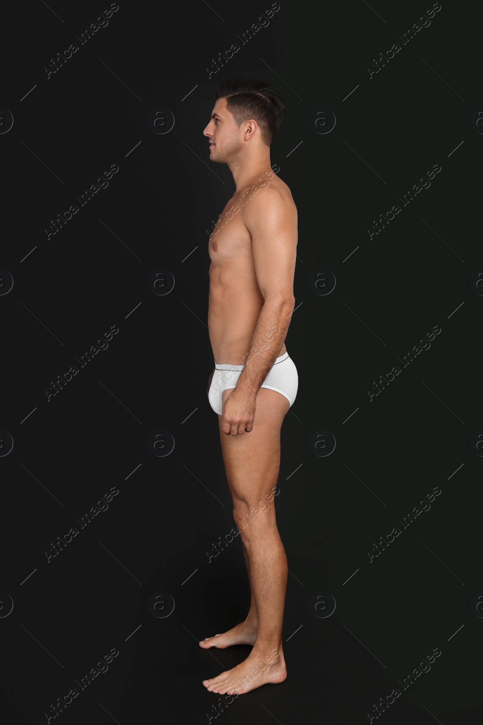 Photo of Handsome man in underwear on black background