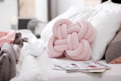 Photo of Pillows and magazines on bed. Idea for interior design