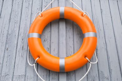 Photo of Orange life buoy hanging on light wooden wall