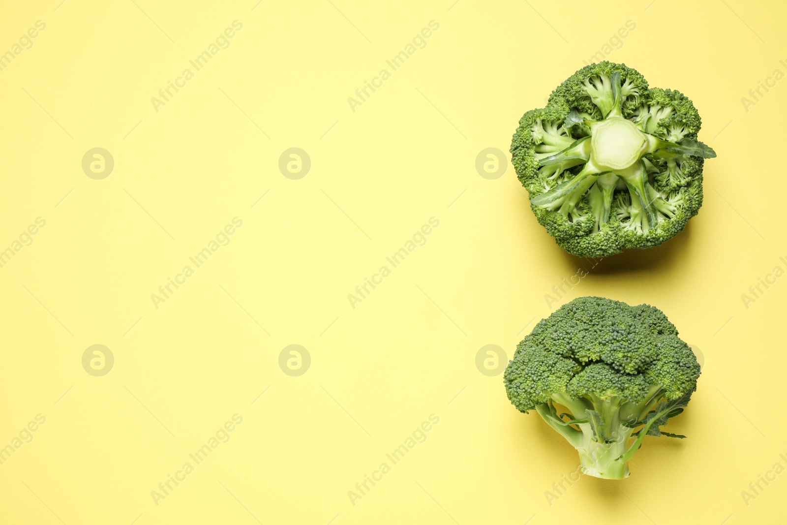 Photo of Fresh tasty broccoli on yellow background, flat lay. Space for text