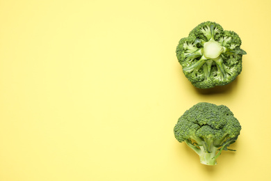 Photo of Fresh tasty broccoli on yellow background, flat lay. Space for text