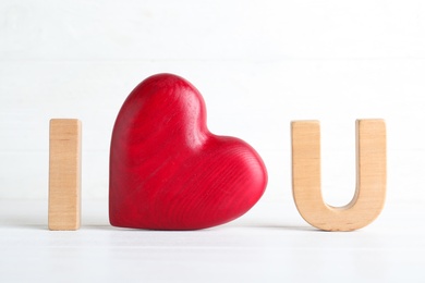 Phrase I Love You made of wooden heart and letters on white background