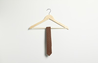 Photo of Hanger with striped necktie on white wall