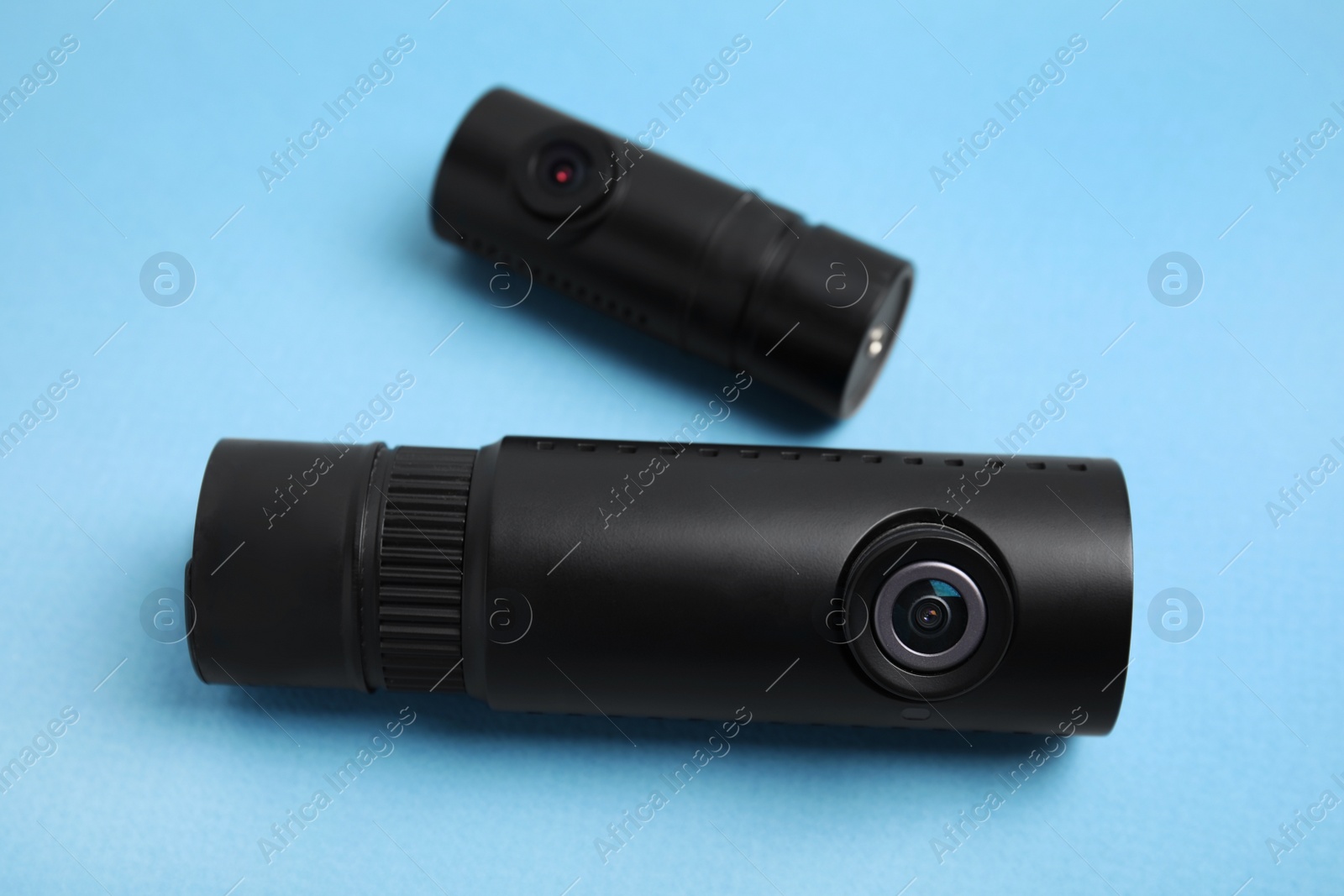Photo of Black modern car cameras on turquoise background, closeup