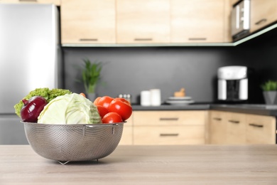 Photo of Fresh vegetables on wooden table in kitchen. Space for text