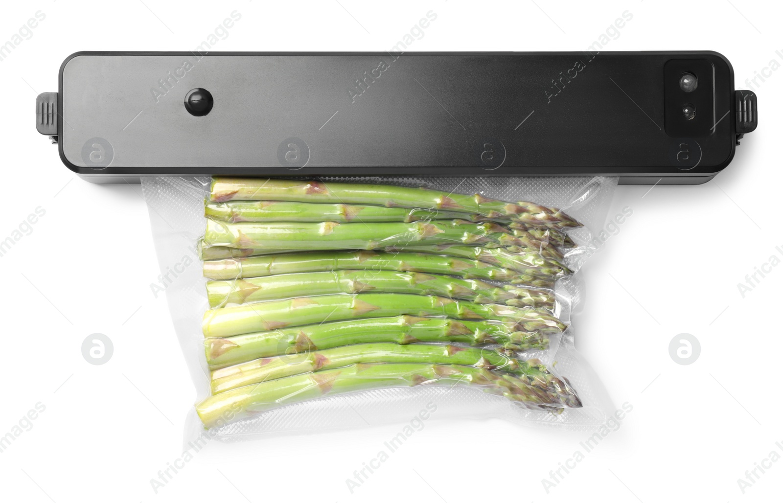 Photo of Sealer for vacuum packing with plastic bag of asparagus on white background, top view