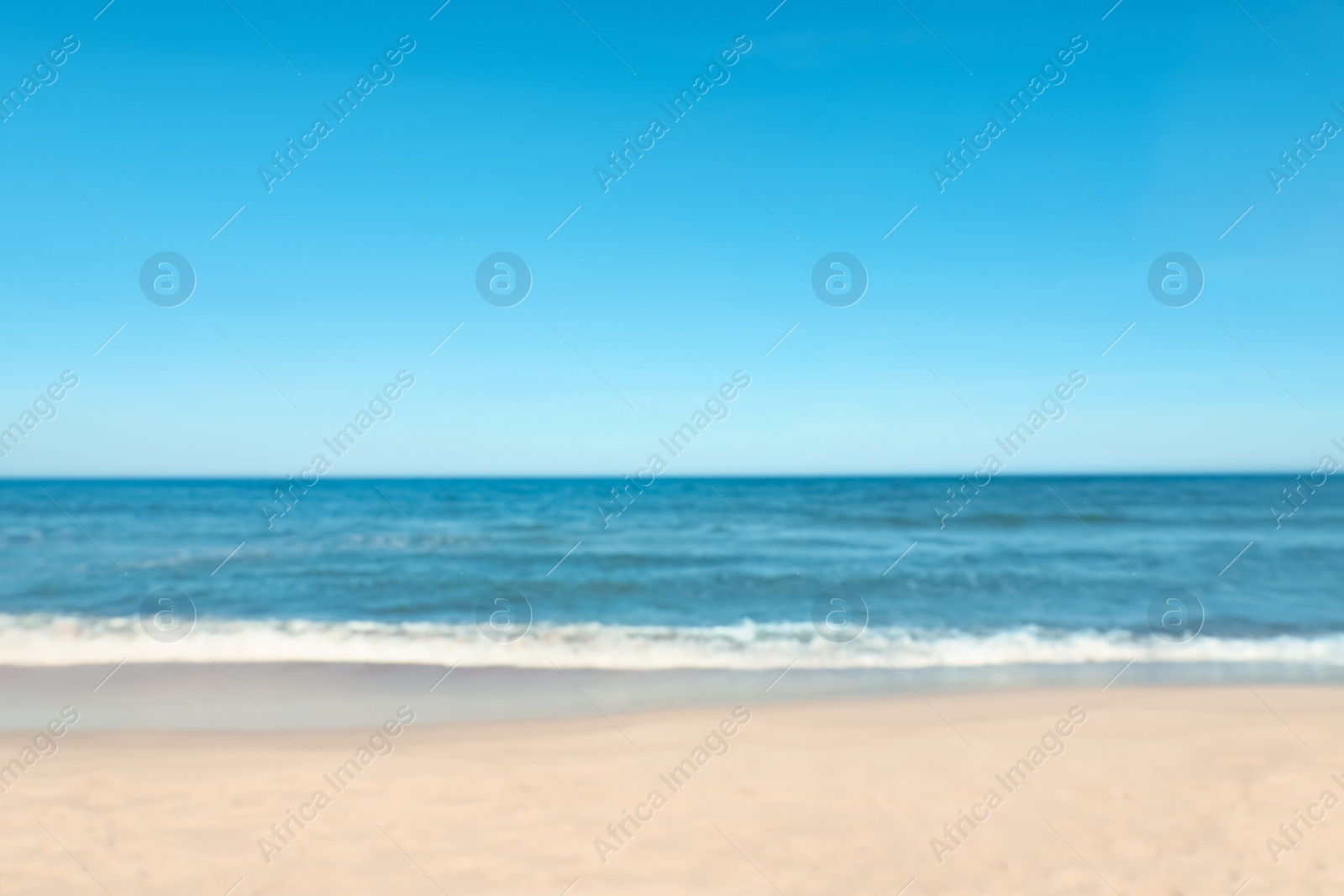 Photo of Blurred view of beautiful sea and sandy beach on sunny day