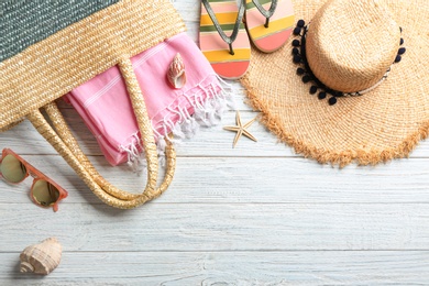 Flat lay composition with beach accessories on wooden background. Space for text