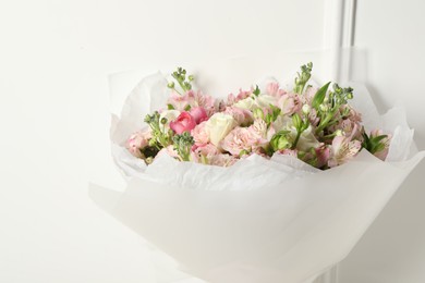 Beautiful bouquet of fresh flowers near white wall