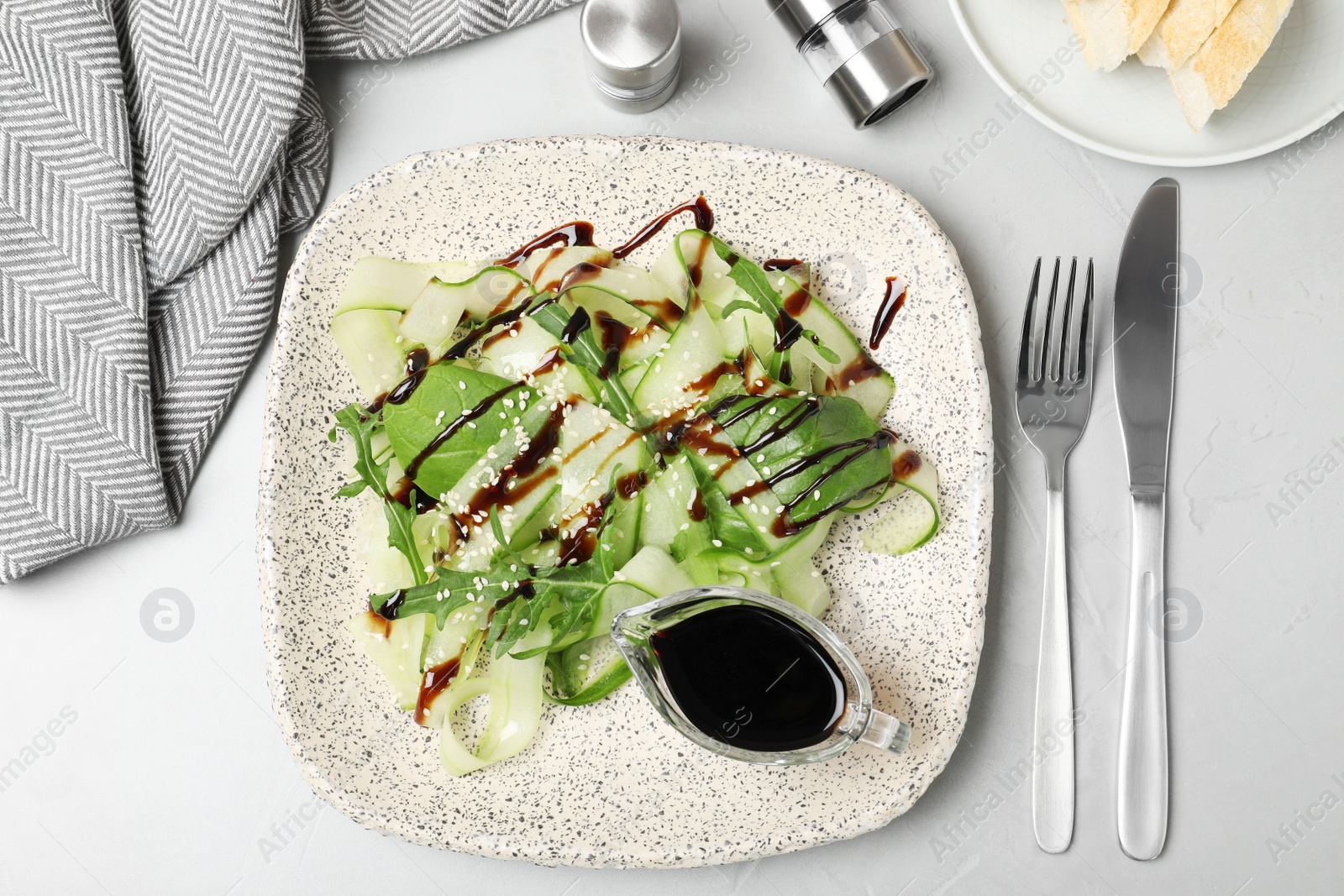 Photo of Vegetable salad served with balsamic vinegar on grey table, top view