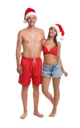 Photo of Happy couple with Santa hats together on white background. Christmas vacation