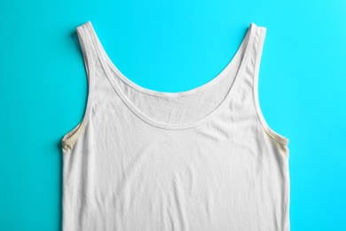 Photo of Undershirt with deodorant stains on light blue background, top view