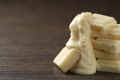 Pieces of white chocolate and tasty paste on wooden table, closeup. Space for text