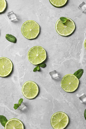 Photo of Flat lay composition with slices of fresh juicy limes on marble table