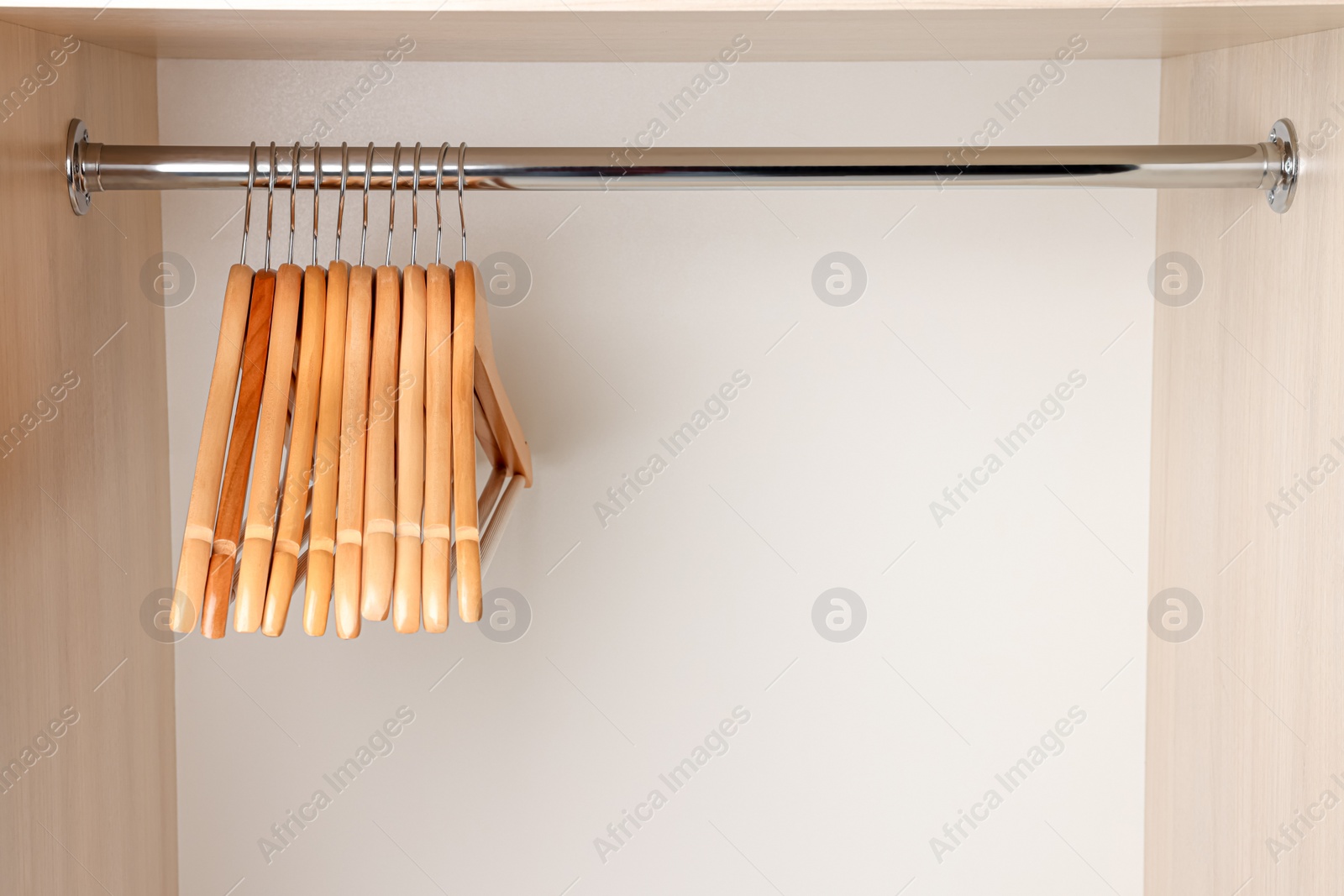 Photo of Set of clothes hangers on wardrobe rail. Space for text