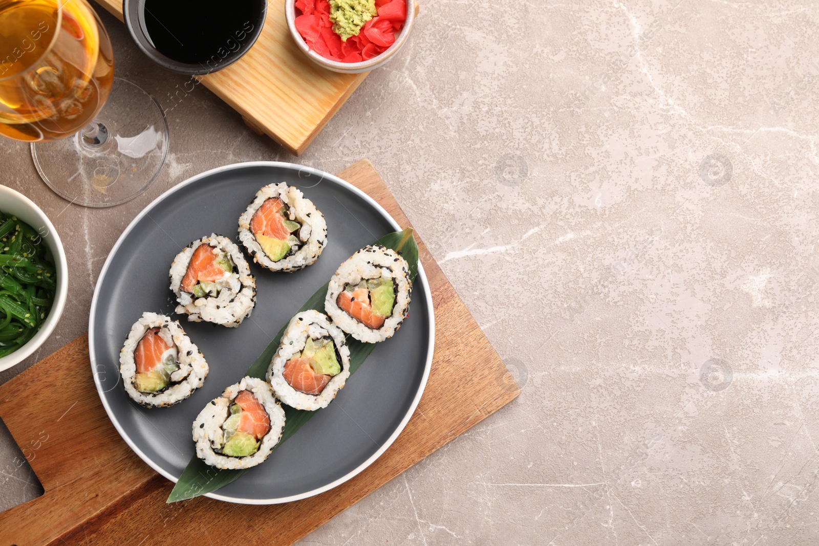 Photo of Flat lay composition with delicious sushi rolls on grey textured table. Space for text