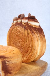 Photo of Supreme croissants with chocolate chips and cream on grey table, closeup. Tasty puff pastry