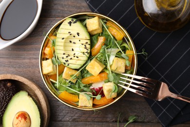Photo of Delicious salad with tofu and vegetables served on wooden table, flat lay