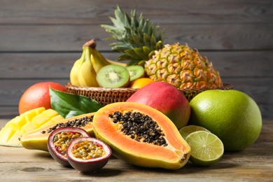 Photo of Fresh ripe papaya and other fruits on wooden table