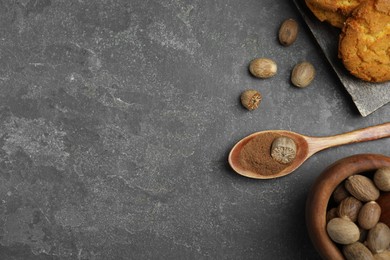 Nutmeg powder, seeds and cookies on grey table, flat lay. Space for text