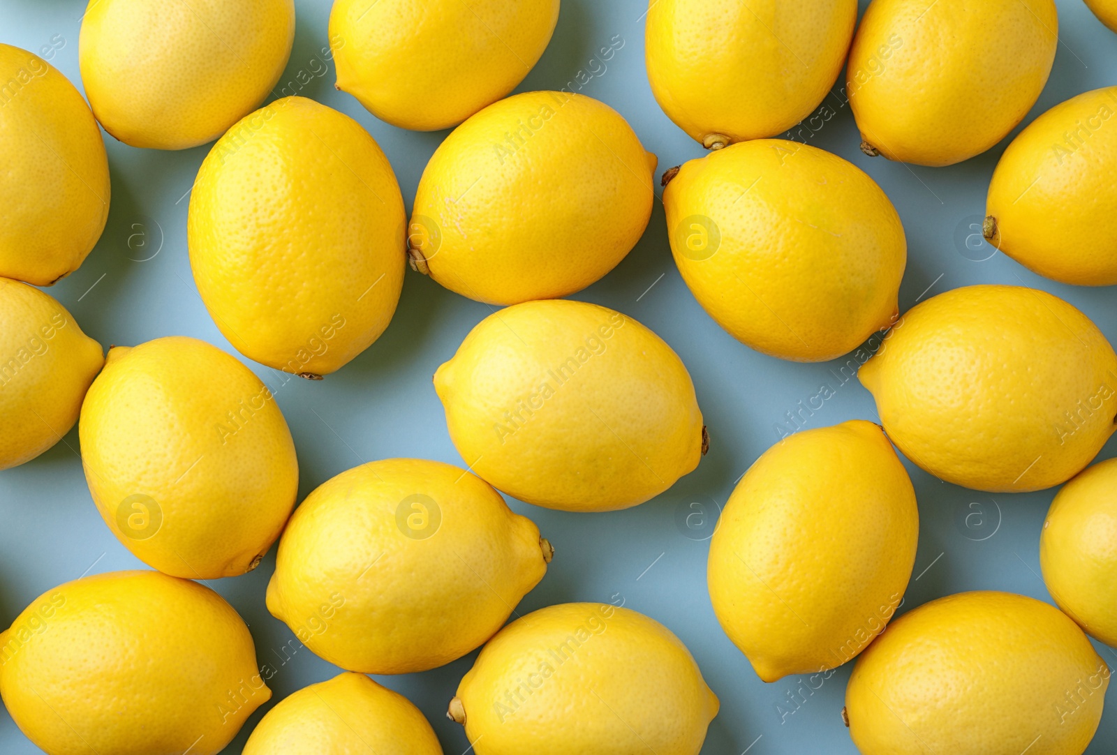 Photo of Ripe fresh lemon fruits on light blue background, flat lay
