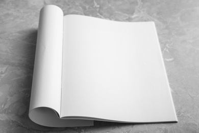 Photo of Blank open book on light grey marble background. Mock up for design