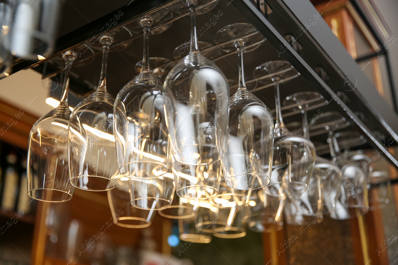 Photo of Many clean glasses on metal rack in restaurant