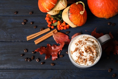 Photo of Cup with tasty pumpkin spice latte on blue wooden table, flat lay