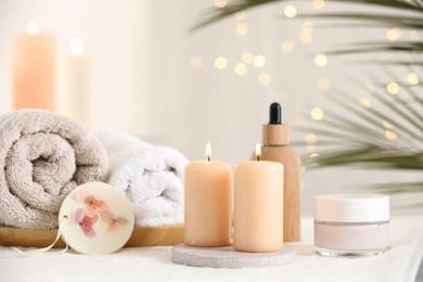 Photo of Spa composition. Burning candles and personal care products on soft surface