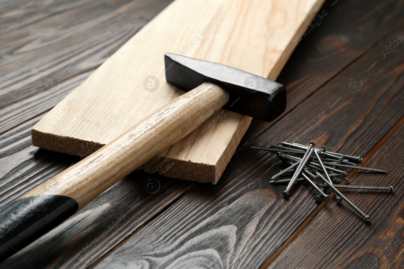 Photo of Hammer and metal nails on wooden table