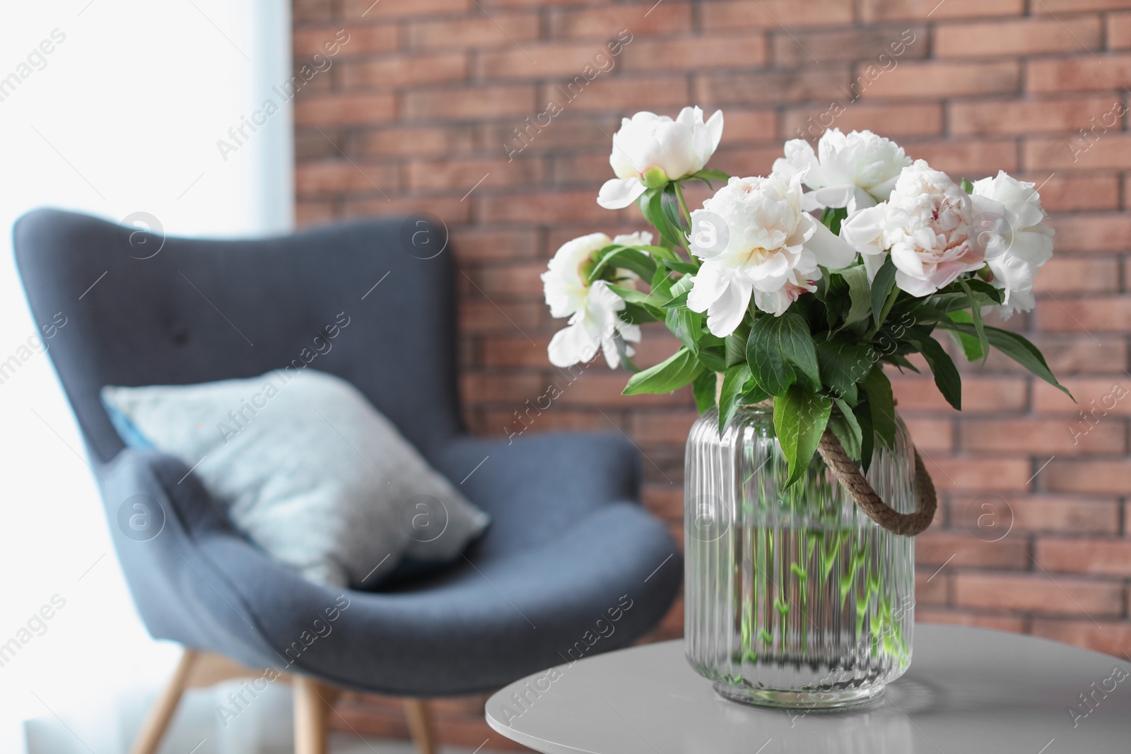 Photo of Vase with beautiful flowers on table indoors. Interior decor element