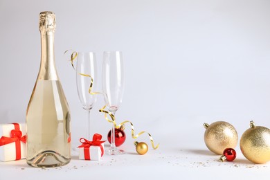 Photo of Happy New Year! Bottle of sparkling wine, glasses and festive decor on white background