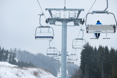 Photo of Man on chairlift at ski resort. Winter vacation