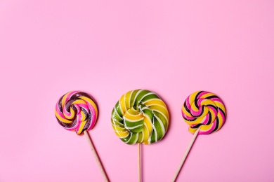 Photo of Bright yummy candies on color background, top view