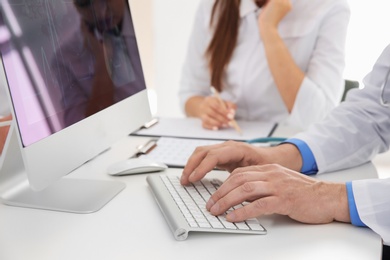 Male doctor working with computer at table. Cardiology center