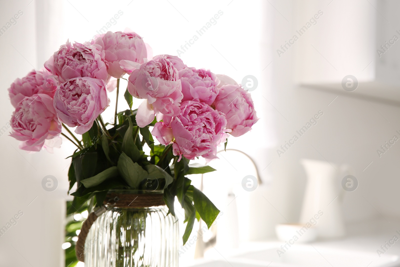 Photo of Vase with bouquet of beautiful pink peonies in kitchen, closeup