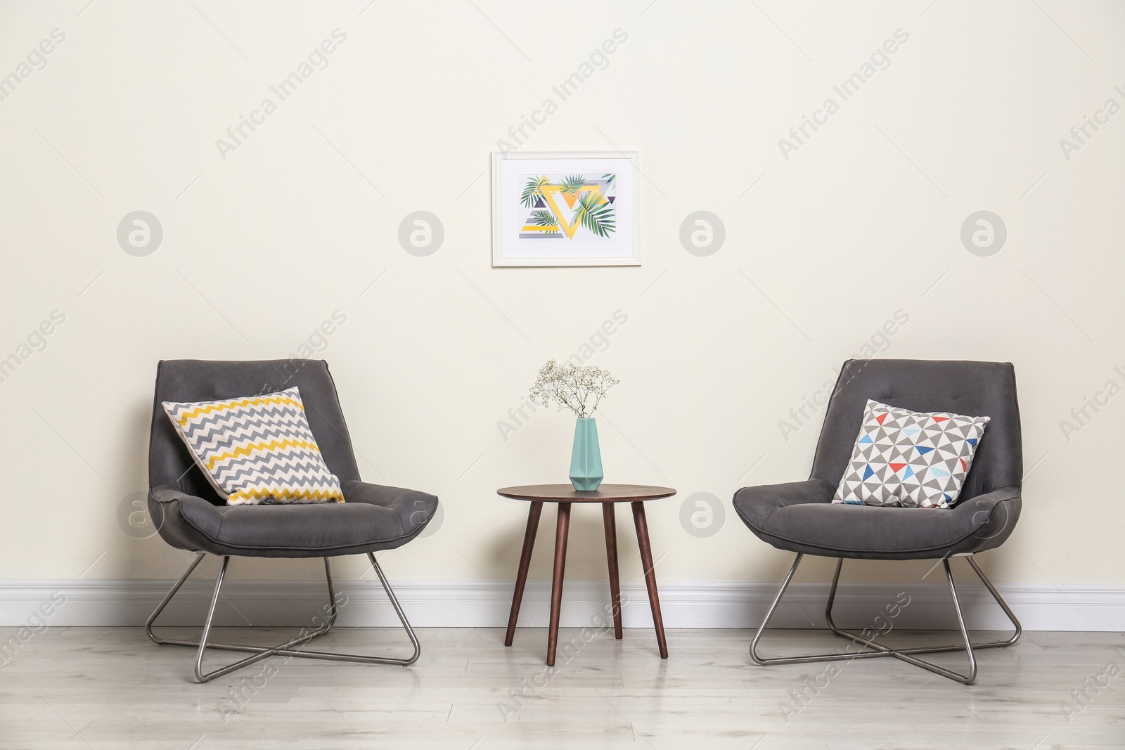 Photo of Room interior with modern chairs and table near light wall